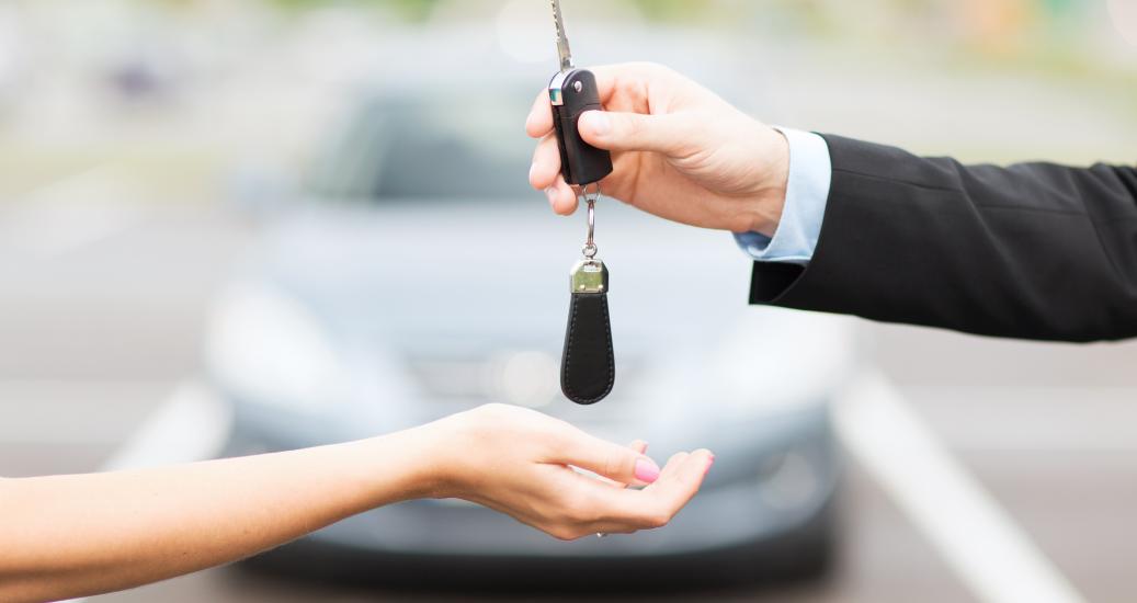 Deux mains se transmettent des clés de voiture