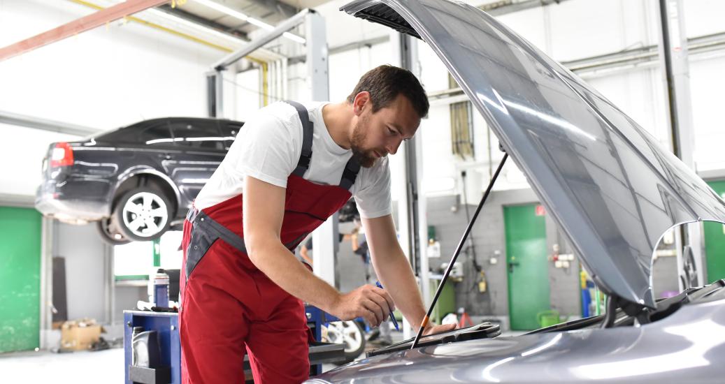 Image d'illustration d'un garagiste inspectant une voiture