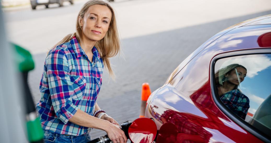 Une femme fait le plein de carburant à la pompe