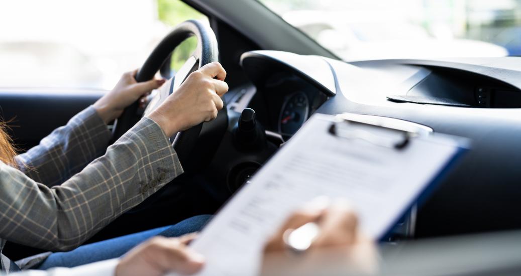 Inspecteur qui note durant l'examen pratique du permis de conduire