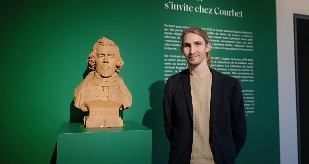 Benjamin Foudral, directeur et conservateur du Musée Courbet à Ornans à côté d'un buste de Eugène Dellacroix