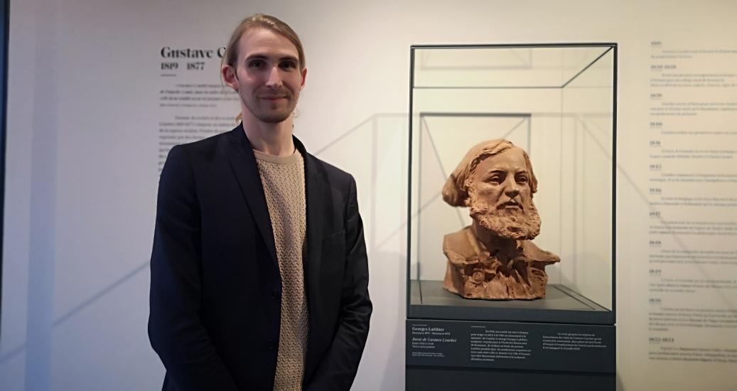 Benjamin Foudral, directeur et conservateur du musée Courbet, devant un buste de Gustave Courbet