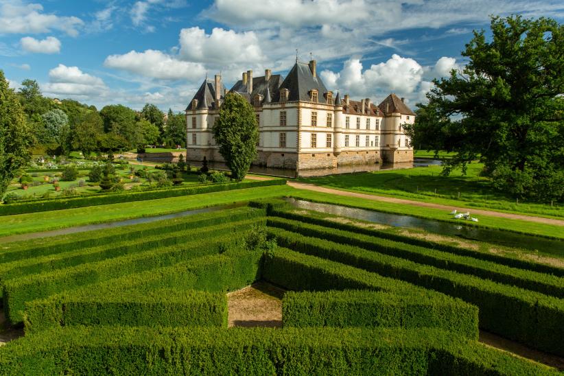 Une vue des château prise depuis un jardin de haies de style français