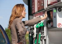 Femme devant station carburant