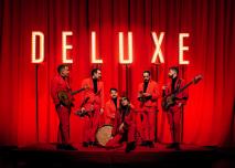 Le groupe Deluxe devant un rideau rouge