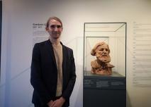 Benjamin Foudral, directeur et conservateur du musée Courbet, devant un buste de Gustave Courbet