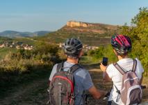 Deux cyclistes regardent leur téléphone devant un paysage montagneux