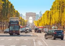 29 July 2019, Paris, France: Buses and cars drive along Avenue Champs Elysees with the Arc de Triomphe in the background